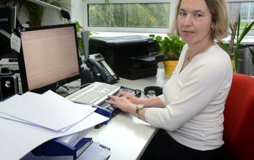 Christine Günzel steckt in ihrem Büro die „Tagesnachrichten“ – mit Braille bedruckte Bögen – in einen großen Umschlag. Auf dem Schreibtisch liegen bereits mehrere befüllte Umschläge.